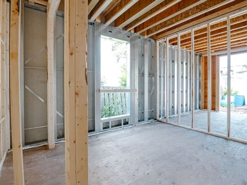 Interior view showing wood and metal stud framing with window openings in multiplex unit