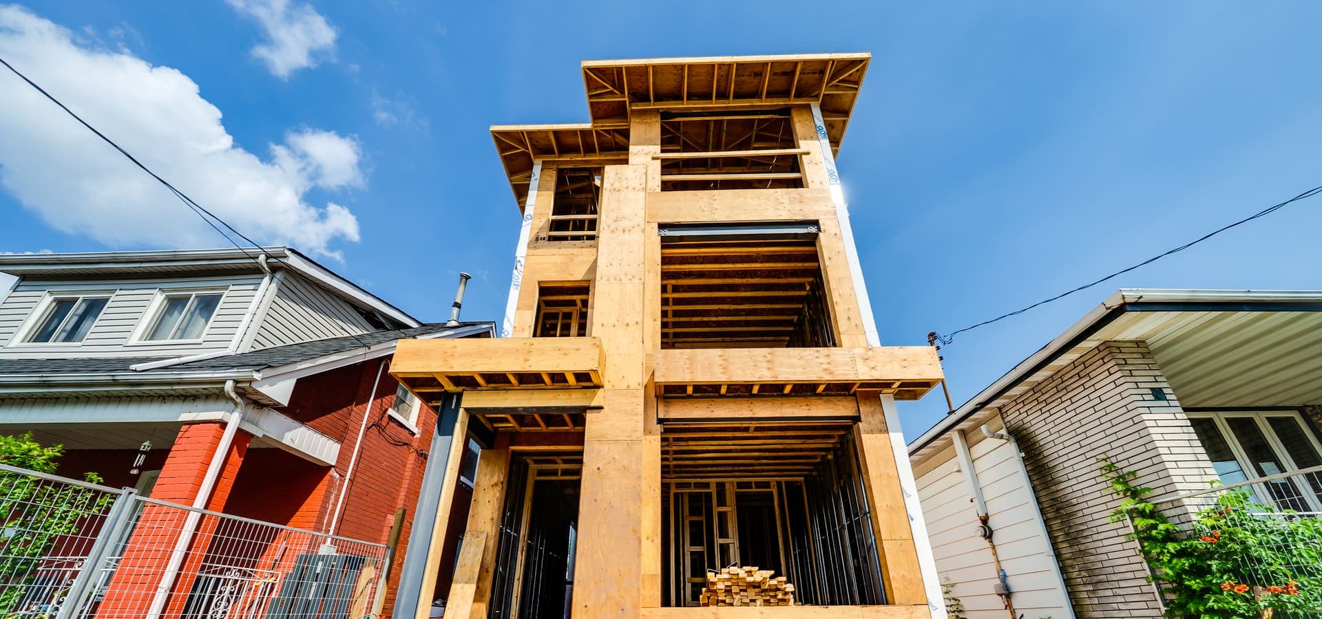 Low angle view of three-storey multiplex framing showing wood structure and floor systems in Hamilton