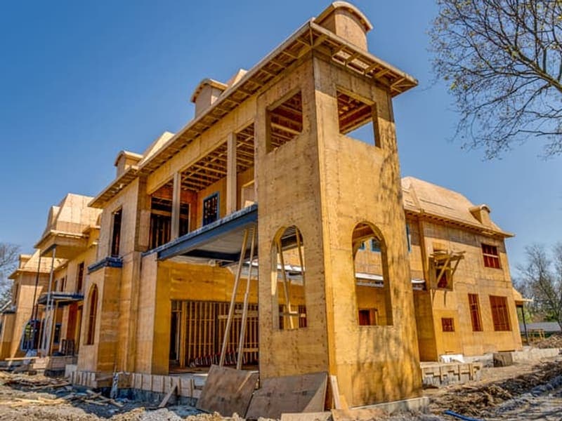 Side elevation of two-storey custom home showing tower feature and arched window details