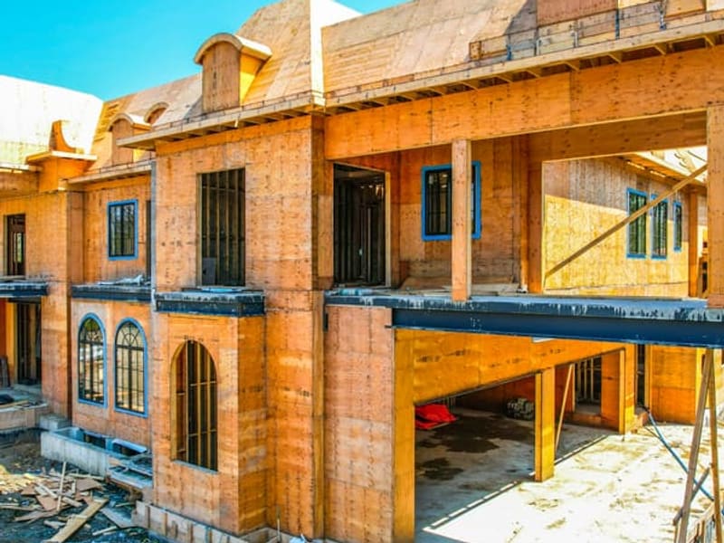Close-up of custom home facade with arched window openings and steel beam supports