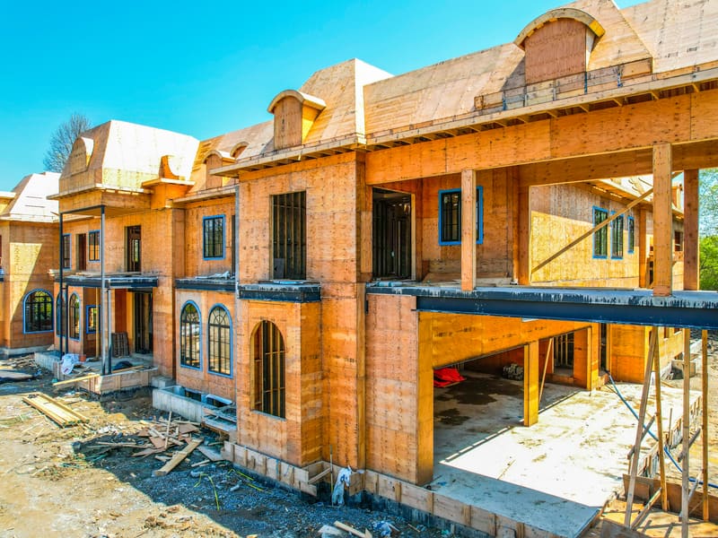 Custom home during wood framing showing arched windows and steel beam supports in Markham