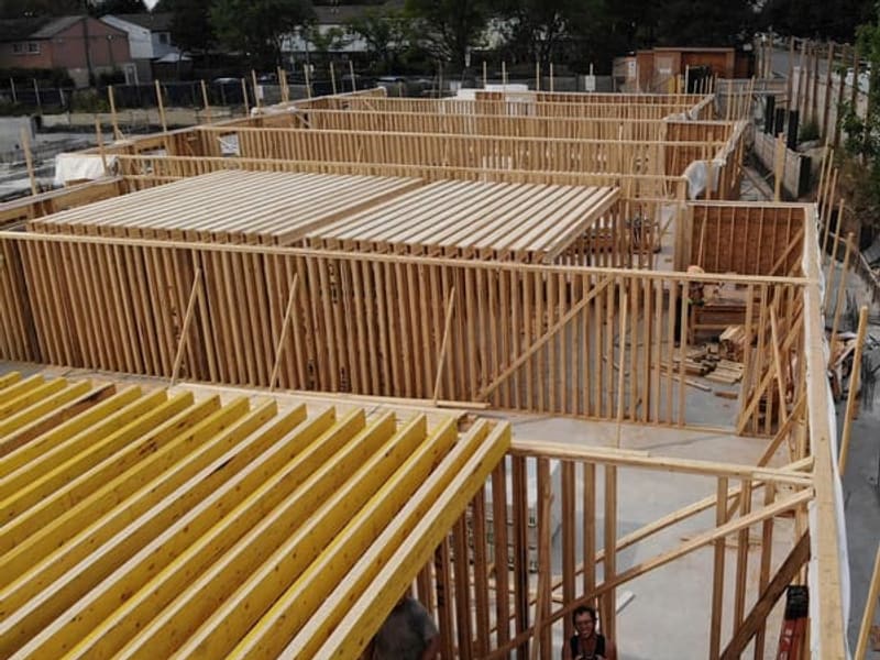 First-floor wood stud wall framing and engineered floor joists during townhouse construction