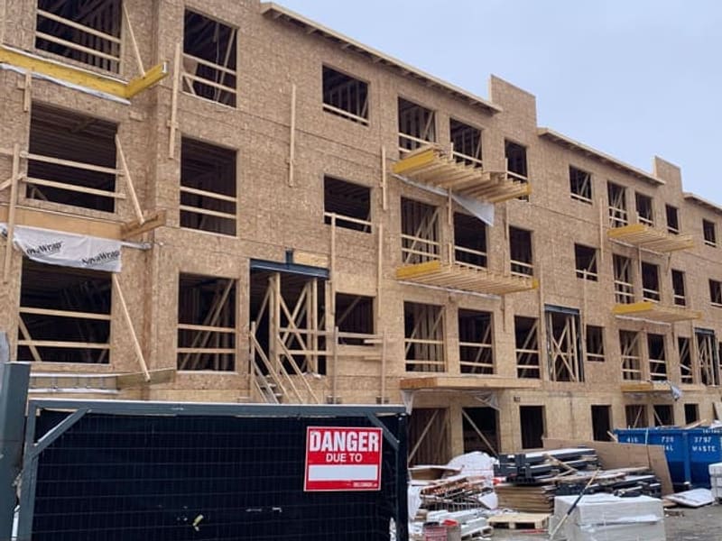 Townhouse block facade with wood framing, OSB sheathing, and balcony framing with engineered lumber