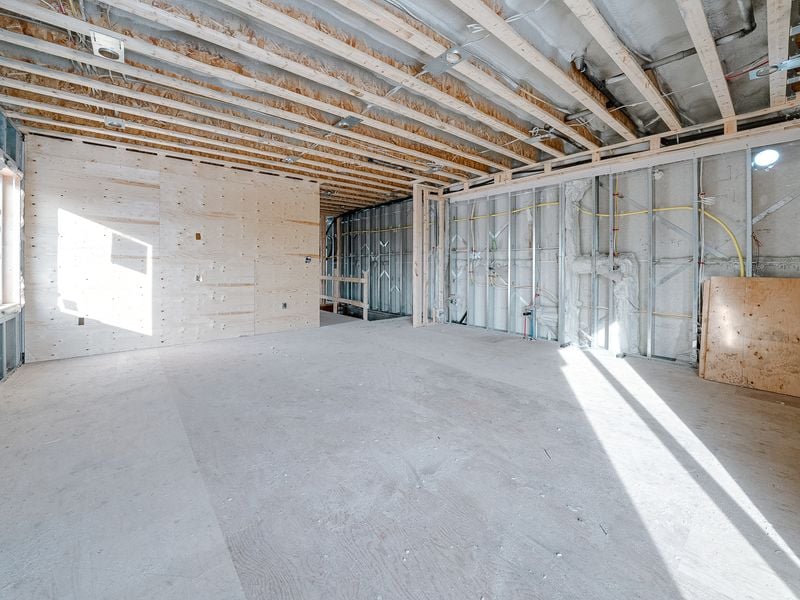 Basement interior with metal stud framing, wood joists, and plumbing rough-in