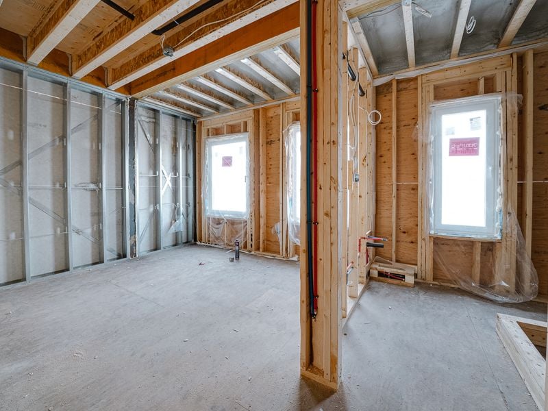 Interior wood and metal stud framing with plumbing rough-in and window openings