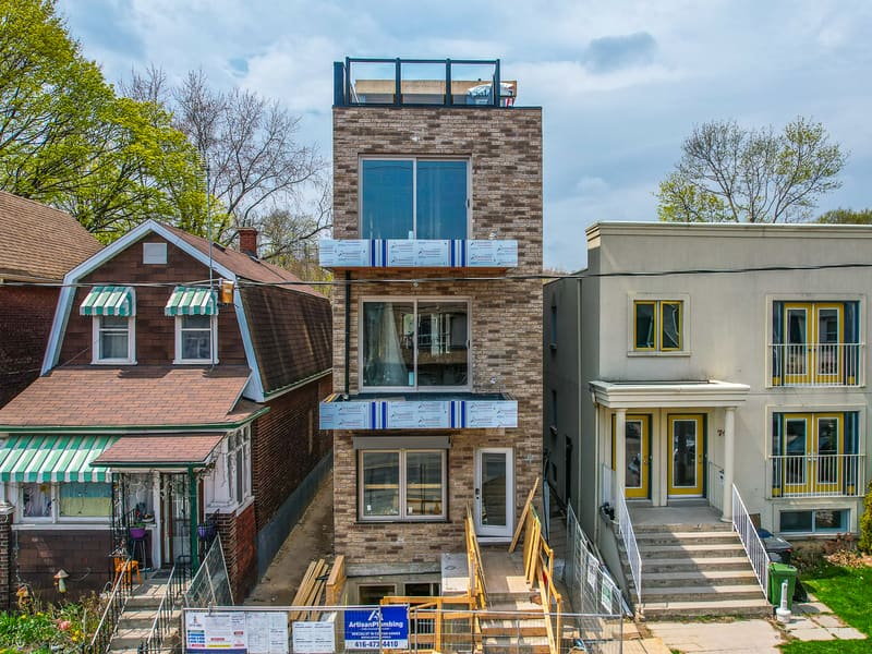 Front elevation of four-storey multiplex with brick facade and rooftop terrace in Leslieville