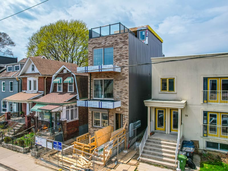 Side view of multiplex showing brick and dark metal panel cladding with balconies