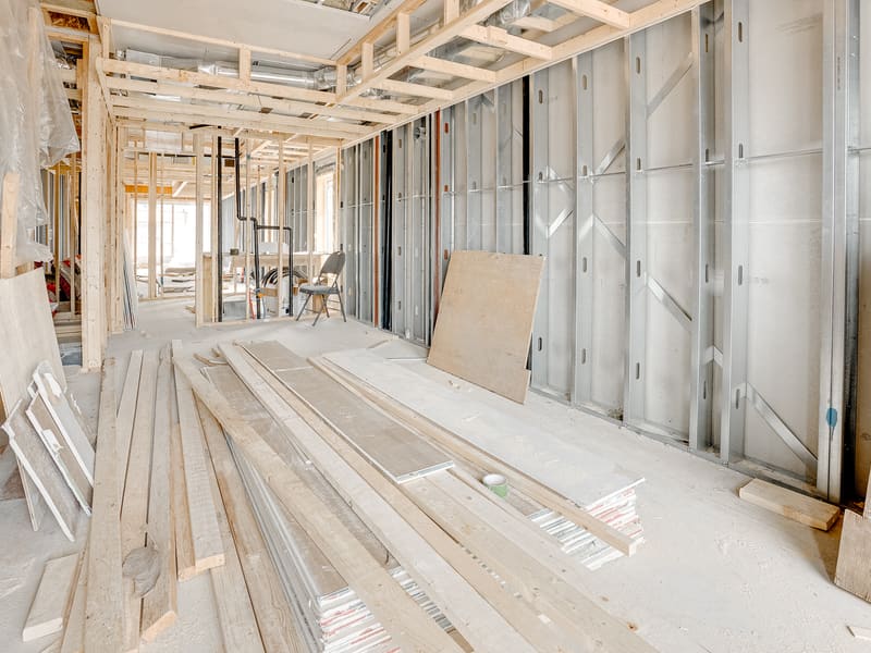 Interior view of metal stud framing with drywall staging and open floor plan layout