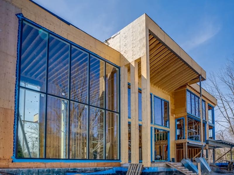 Side elevation showing double-height window wall and exposed wood beam structure