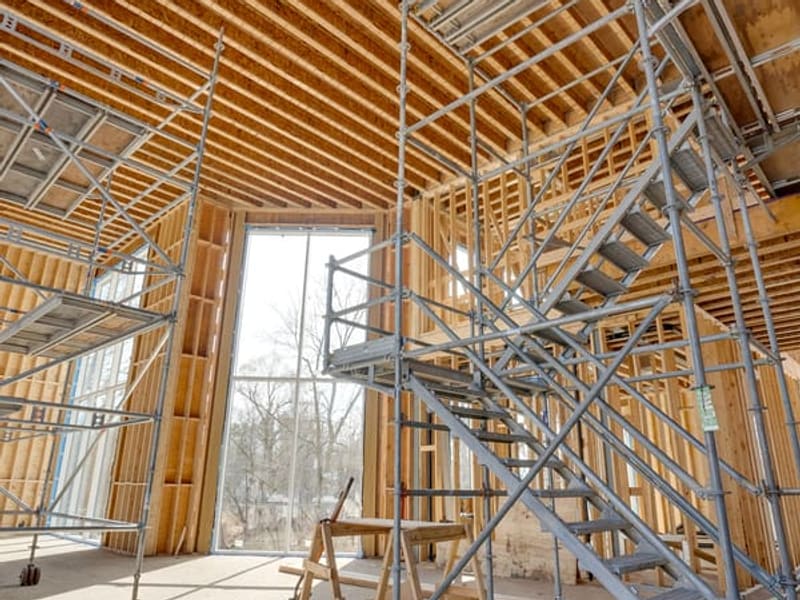Interior view with scaffolding showing 20-foot ceiling height and tall window framing