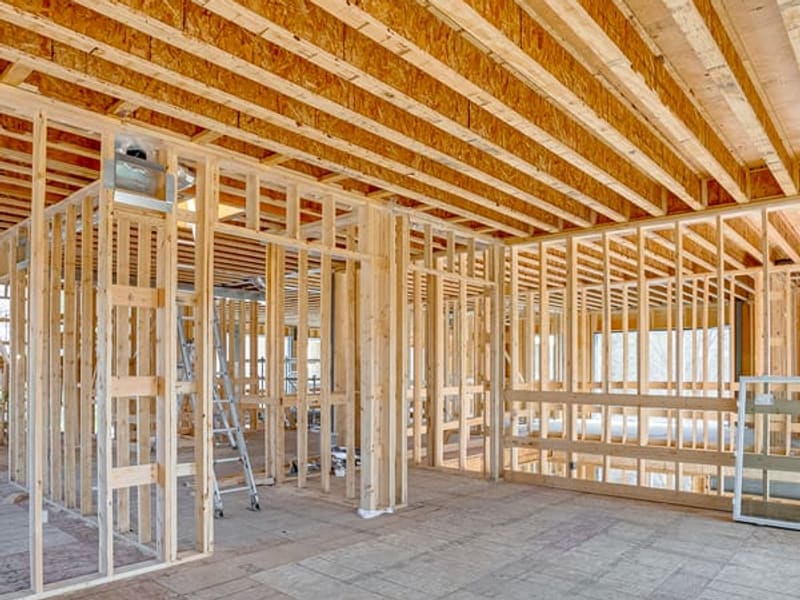 Interior wood stud framing with floor joists and open concept layout for custom home