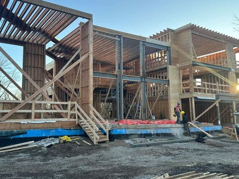 Construction progress showing steel moment frames and wood framing at sunset in Brampton