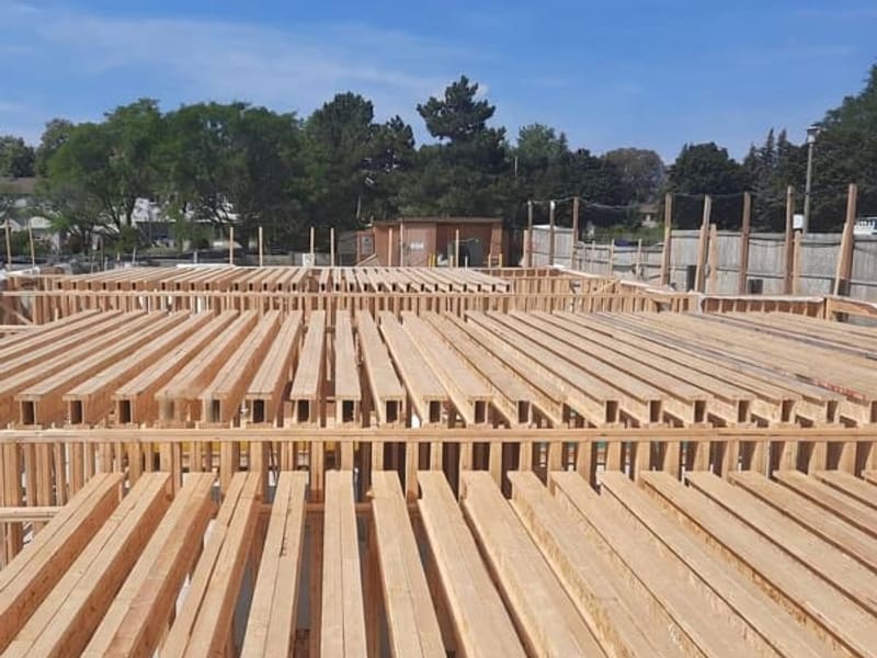 Rows of engineered floor joists spanning across townhome block during framing