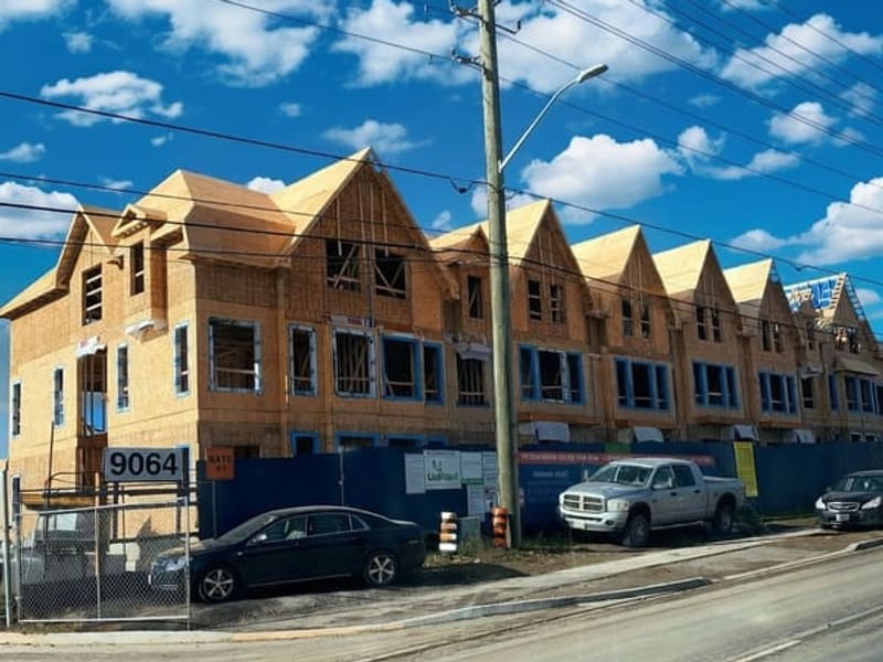 Street view of 9064 Woodbine Ave townhome block showing wood framing and roof trusses