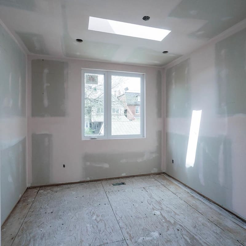 Drywall finishing in progress showing skim coat application