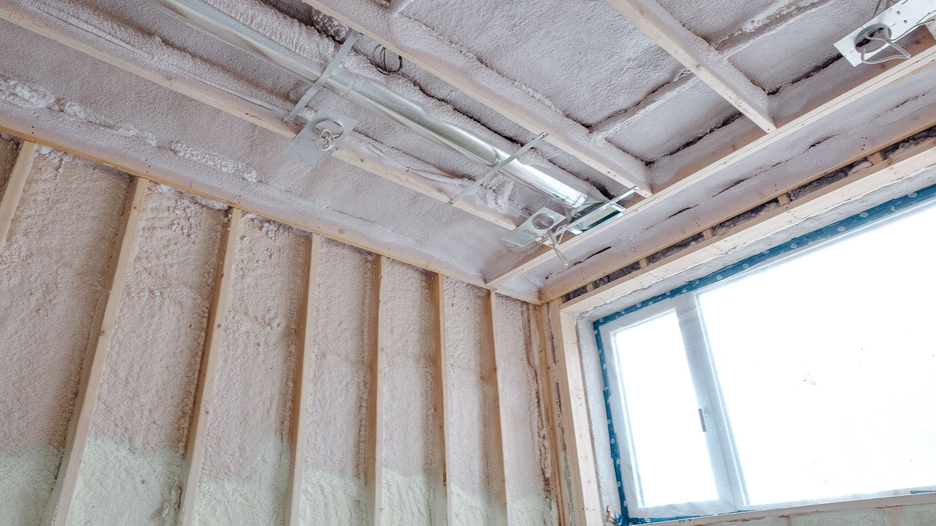 Spray foam insulation being applied to wall